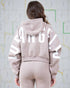 Person wearing a beige hoodie with 'LOS ANGELES' printed on the back against a map background