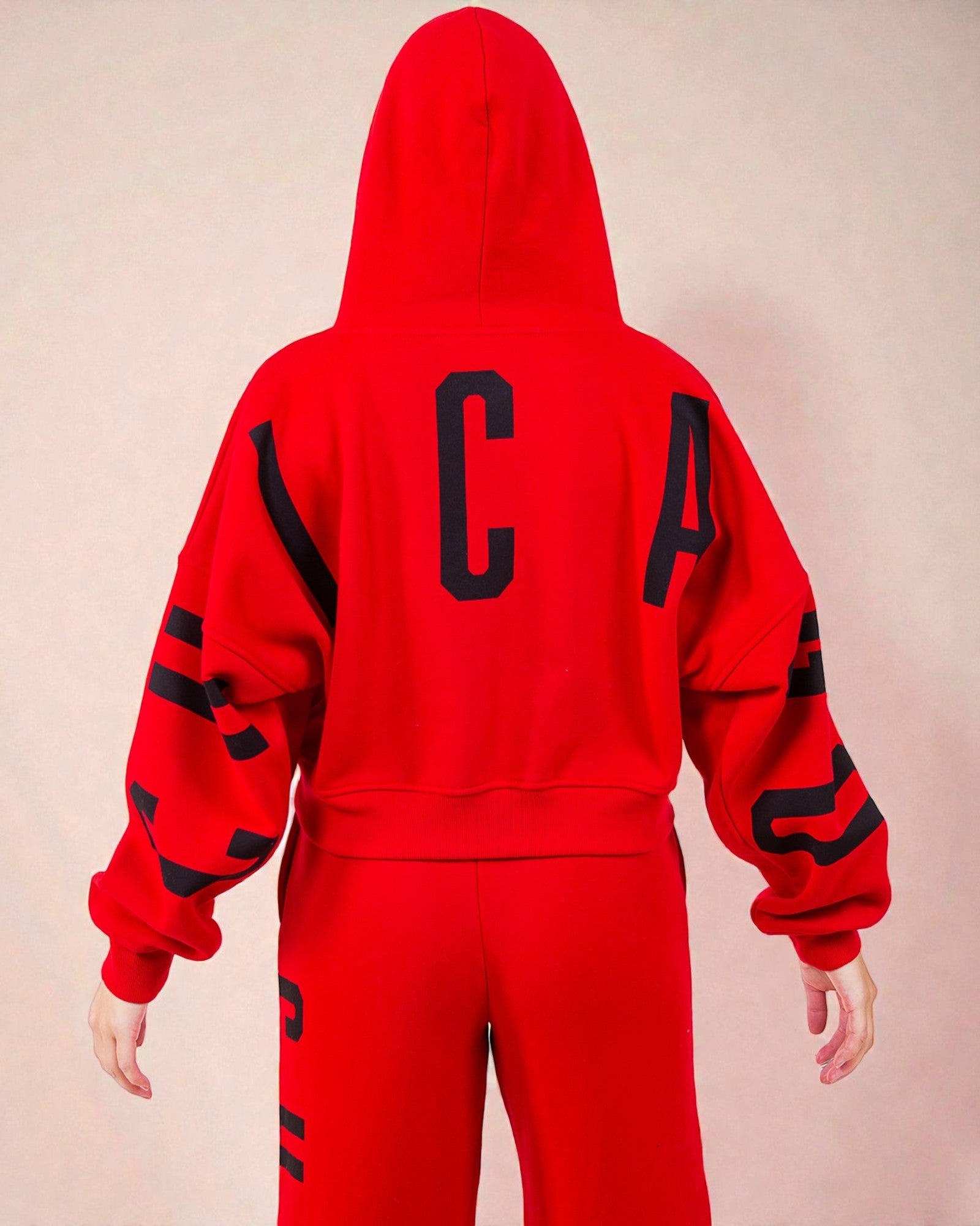 Red hoodie and pants with black lettering on a beige background
