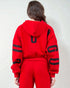 Person wearing a red hoodie and pants with black lettering on a light gray background