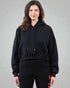 Person wearing a black hoodie and black pants with red accents on a gray background
