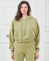 Woman wearing a green hoodie and pants against a white background