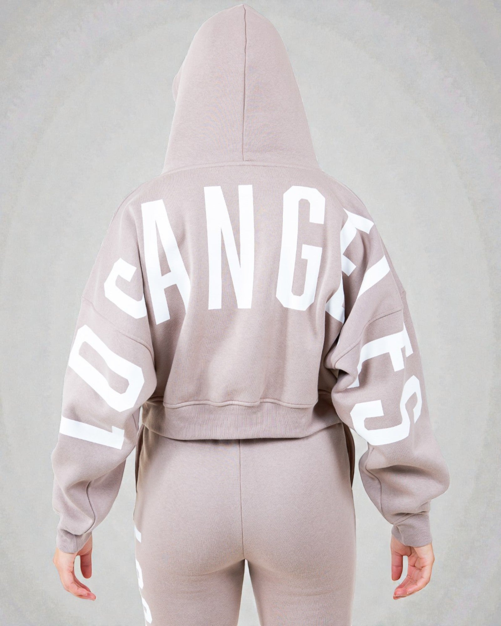 Light pink hoodie with 'Los Angeles' text on the back against a gray background