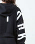 Black hoodie with white text on sleeves against a light gray background