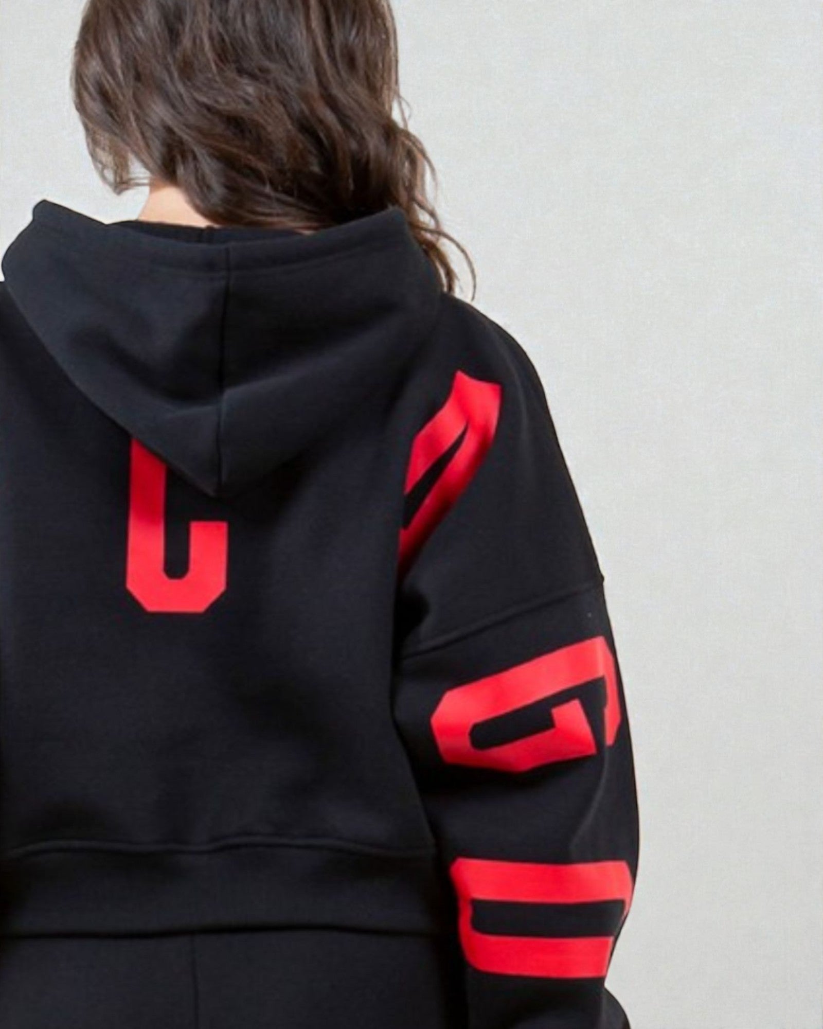 Black hoodie with red lettering on a plain background