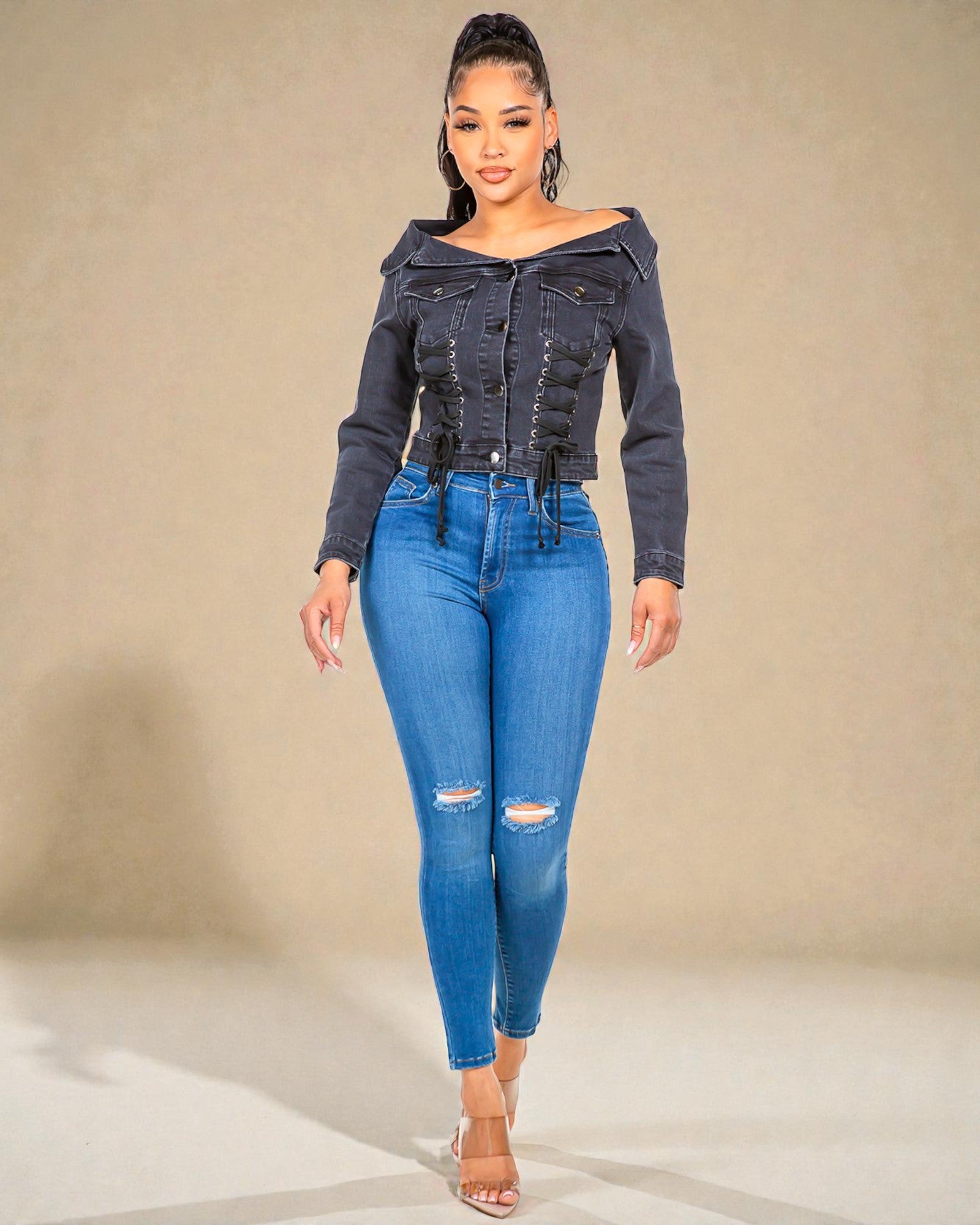 Woman wearing a denim jacket and jeans against a neutral background