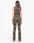 A woman viewed from the back wearing a sleeveless camouflage jumpsuit with a fitted waist and straight-leg pants, standing against a plain light gray studio background.