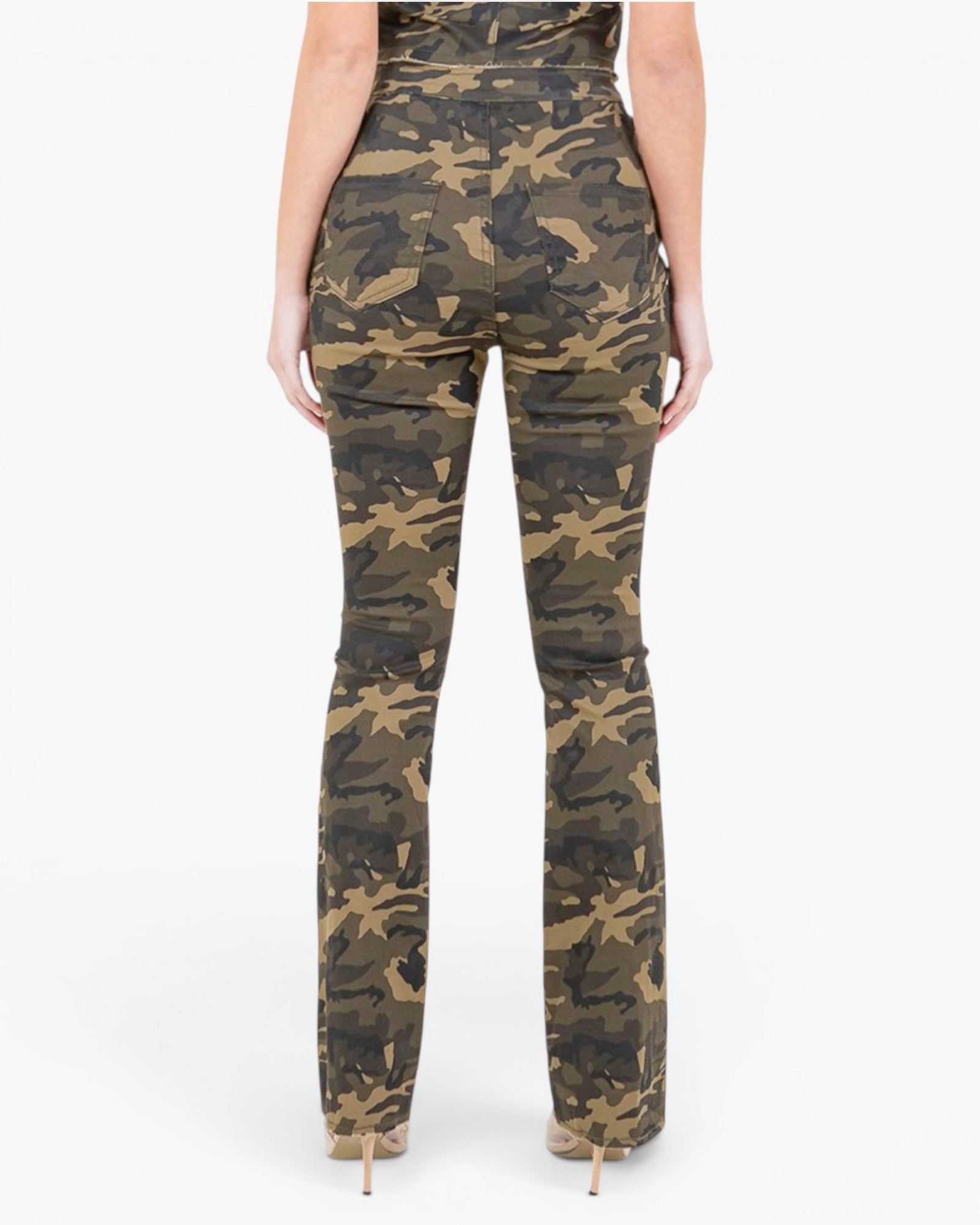 Back view of a model wearing high-waisted camouflage pants with a subtle sheen, paired with beige high-heeled shoes against a plain white background.
