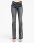 A pair of high-waisted, dark gray flared jeans with a ruched front and frayed hems, shown on a model wearing clear high-heel sandals against a white studio background.