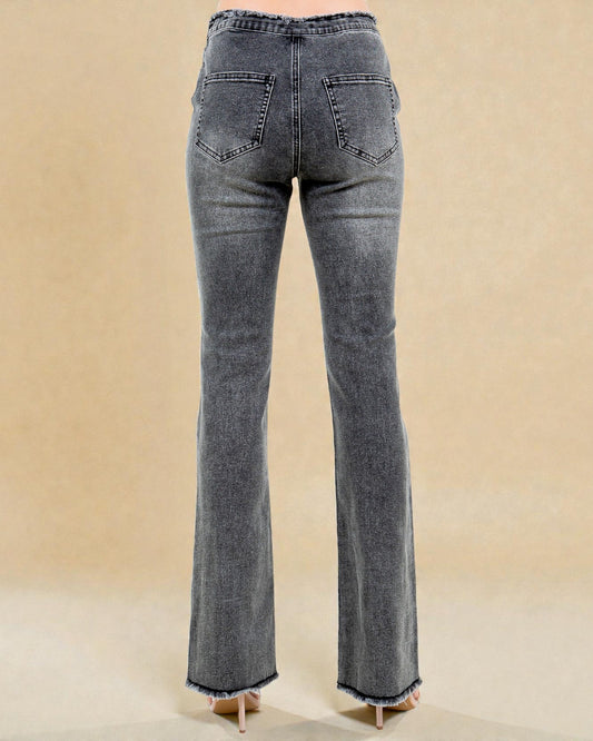 Pair of gray flared jeans on a beige background