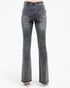 Back view of a person wearing gray denim flare jeans with frayed hems and light-colored high heels, photographed against a plain white studio background.