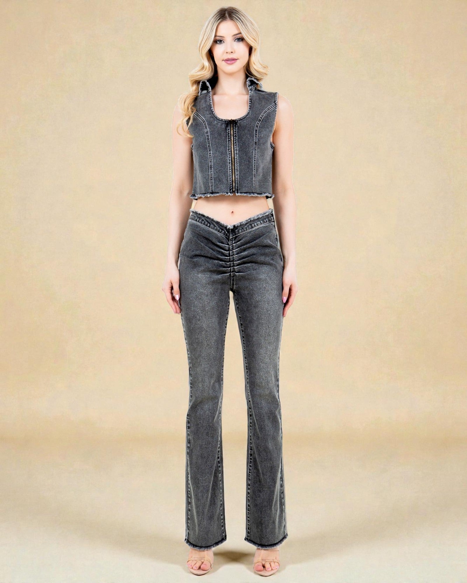 Woman wearing a denim crop top and flared jeans on a beige background