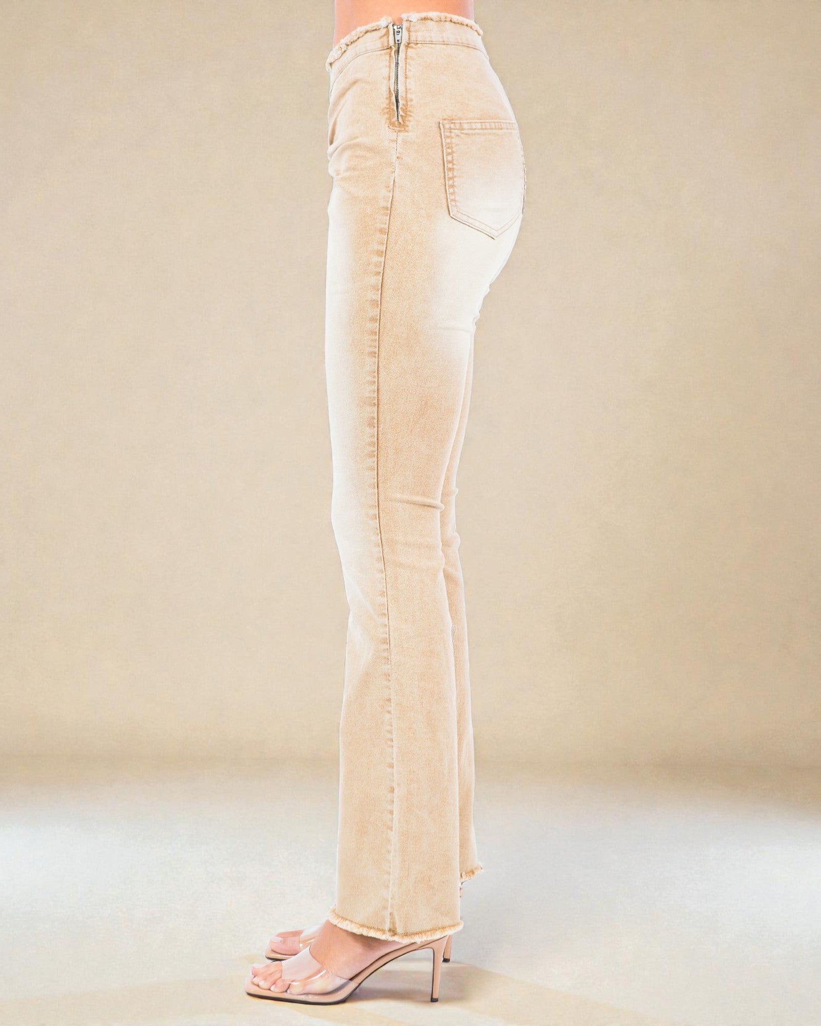 Beige jeans worn by a person on a plain background