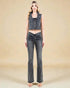 Woman wearing a denim crop top and flared jeans on a beige background