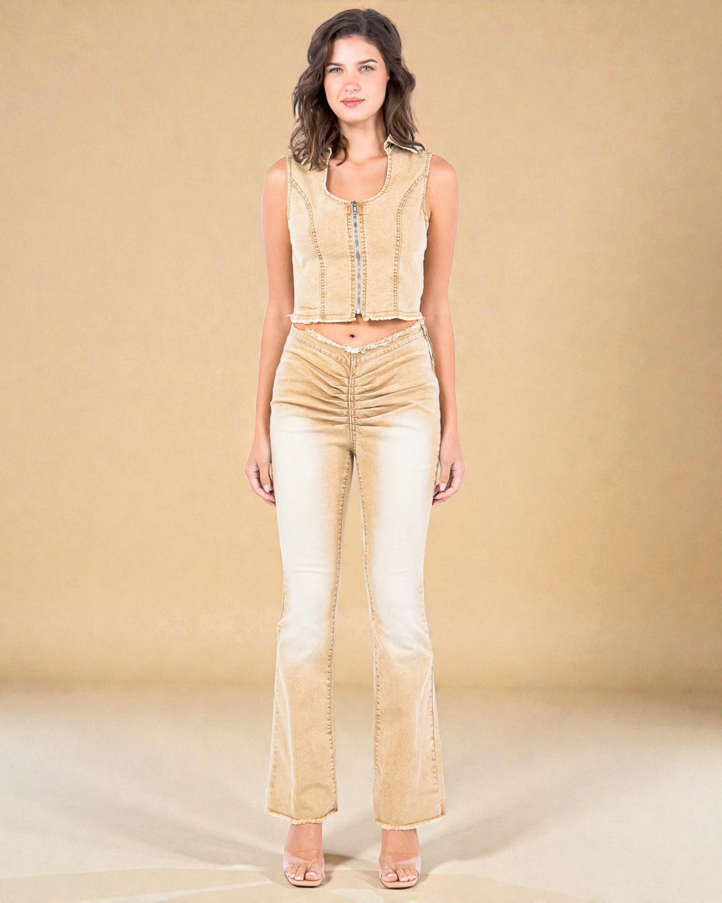 Woman wearing a beige sleeveless top and flared pants against a beige background