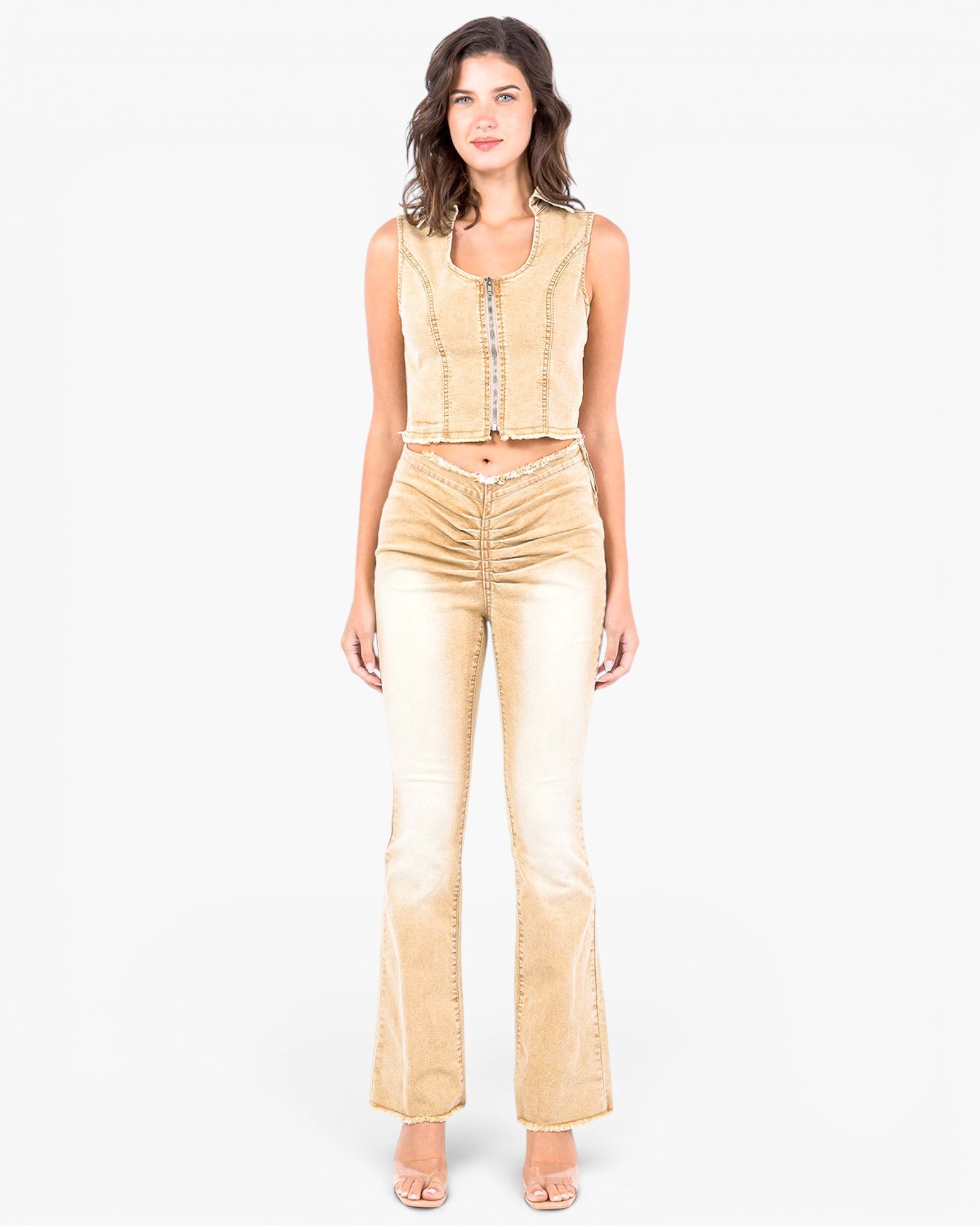 A woman modeling a matching two-piece outfit consisting of a sleeveless cropped vest and high-waisted flared pants, both in a light beige/champagne velvet-like fabric with gold trim details, set against a plain white background.