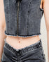 Person wearing a black denim vest over a white shirt