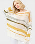 Woman wearing a striped sweater with yellow, green, and white colors on a plain background