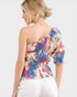 Woman wearing a colorful one-shoulder top on a white background
