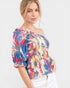 Woman wearing a colorful off-shoulder top on a white background