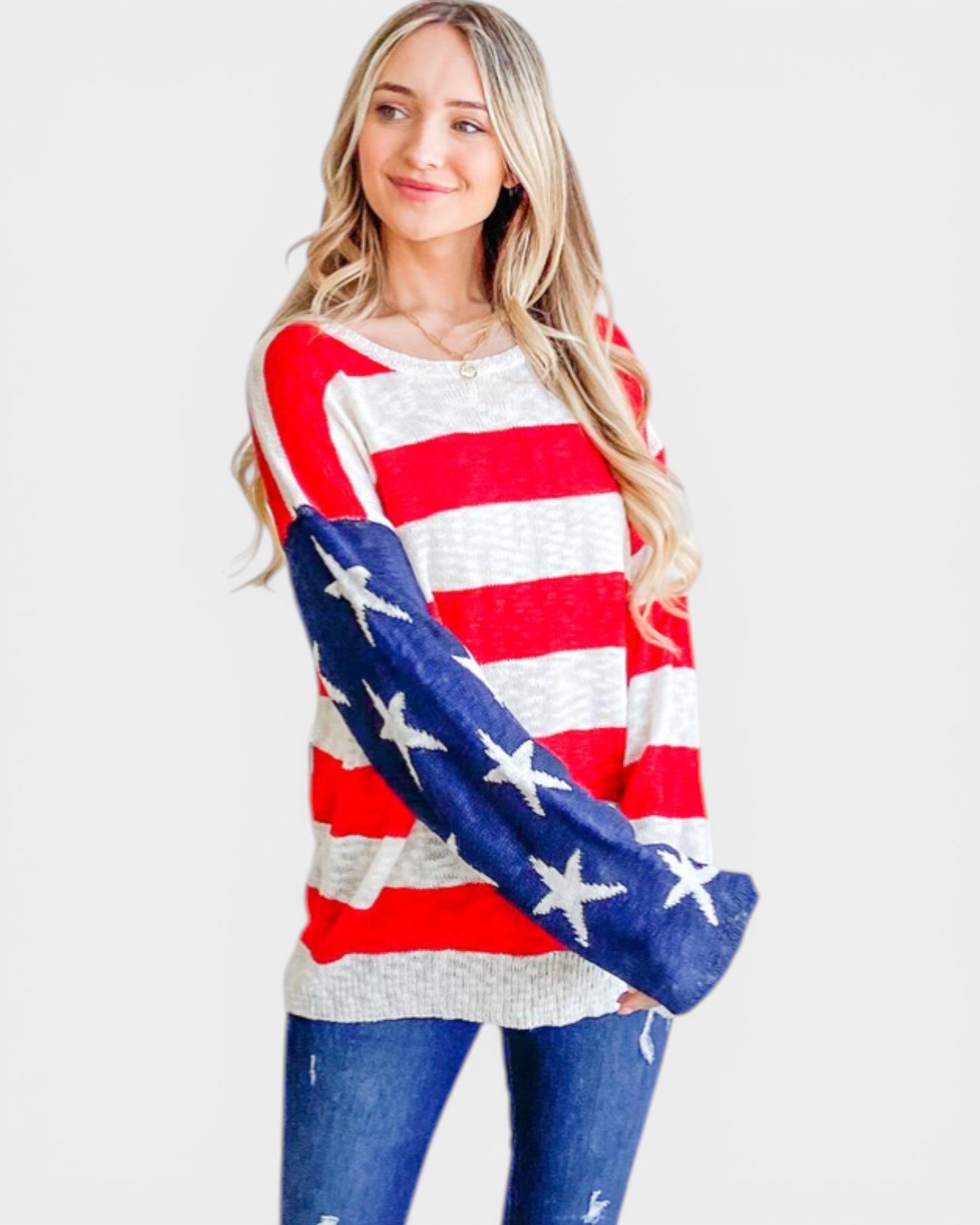 Woman wearing a red, white, and blue striped sweater with star patterns on a plain background