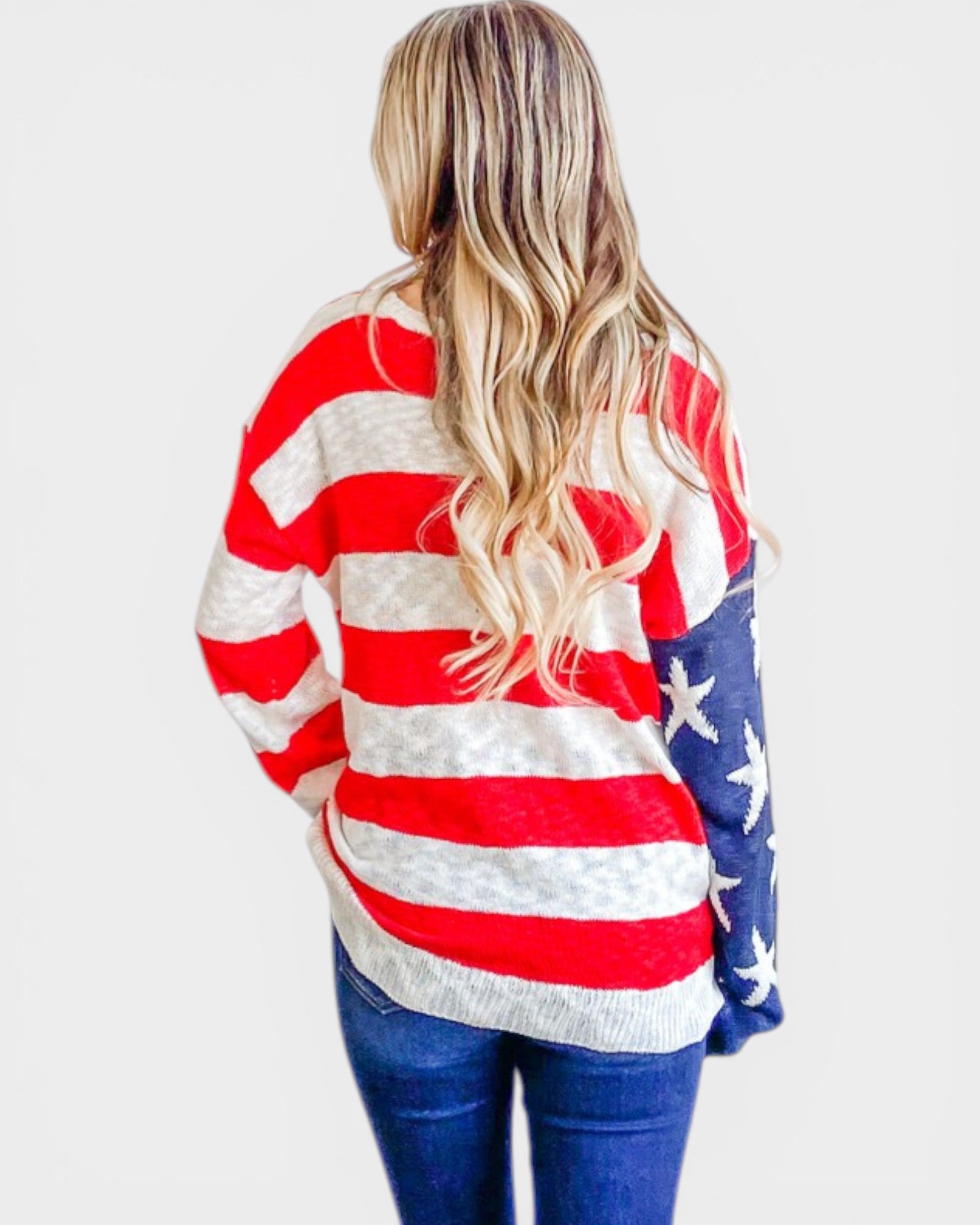 Person wearing a red, white, and blue striped sweater with star patterns on a plain background