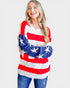 Woman wearing a red, white, and blue striped sweater with star patterns on a plain background