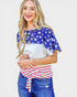 Woman wearing a colorful top with star and stripe pattern on a plain background