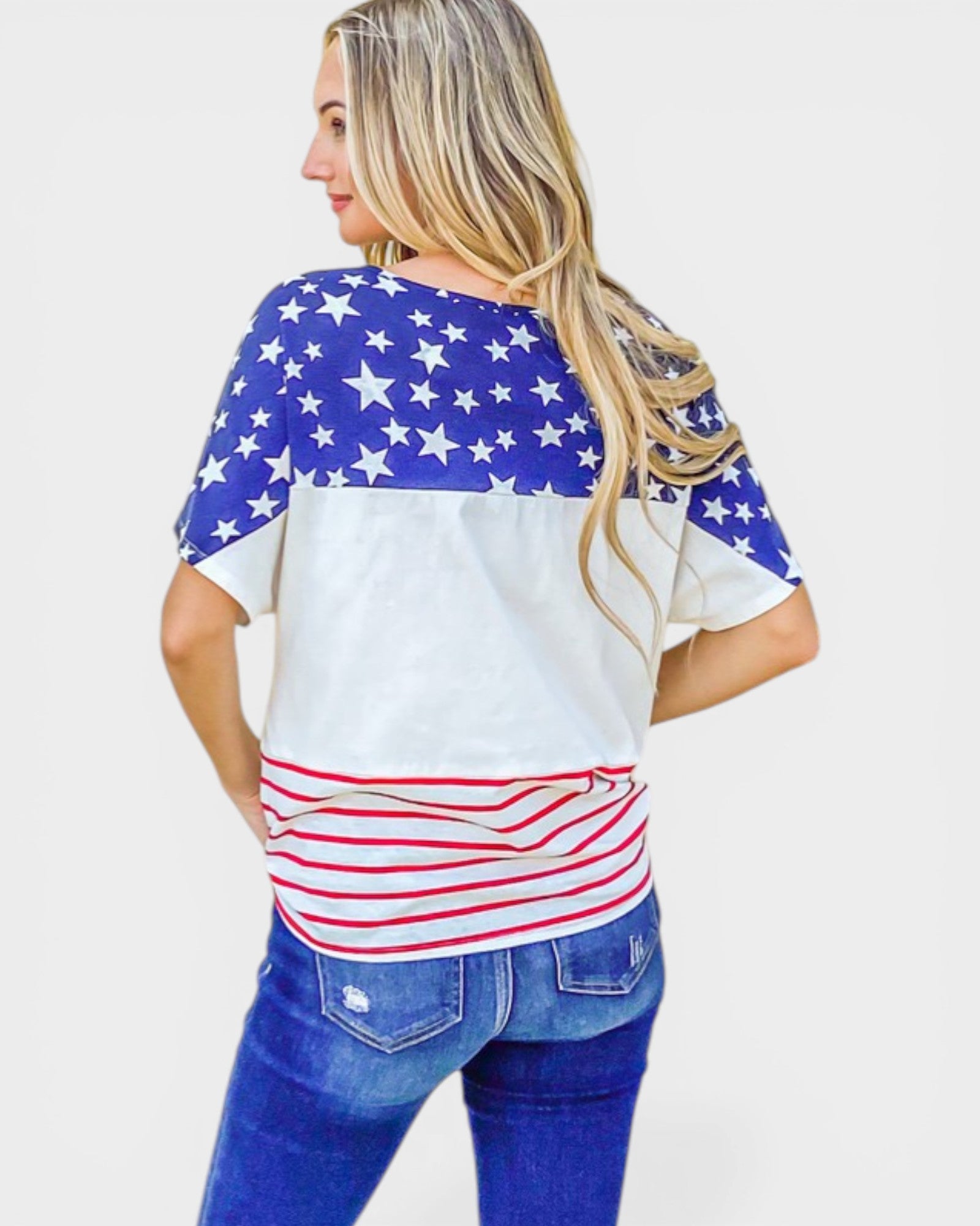 Woman wearing a shirt with an American flag design on a plain background