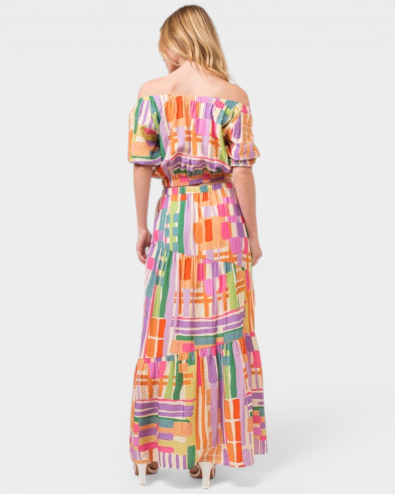 Woman wearing a colorful patterned dress on a white background