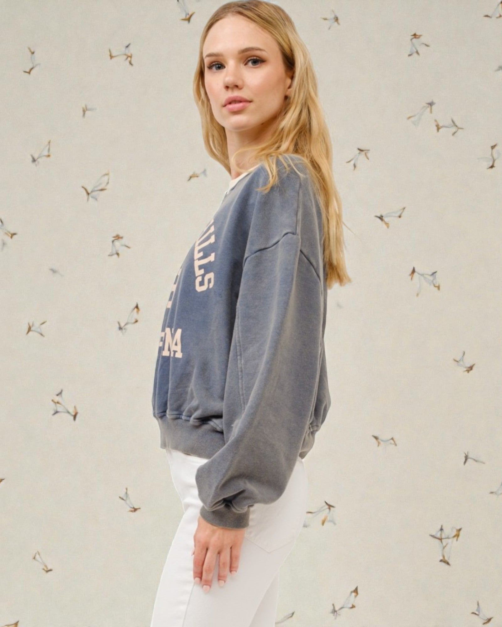 Woman wearing a blue sweatshirt with text on it against a light background