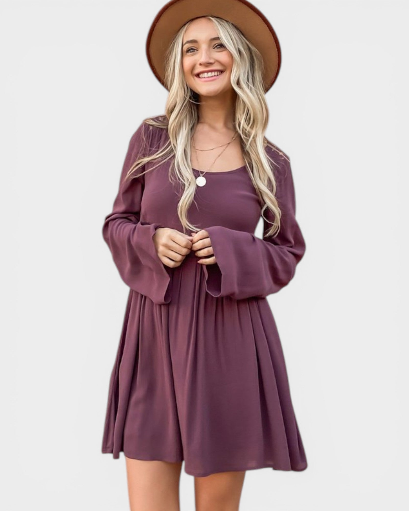 Woman wearing a purple dress and brown hat on a white background