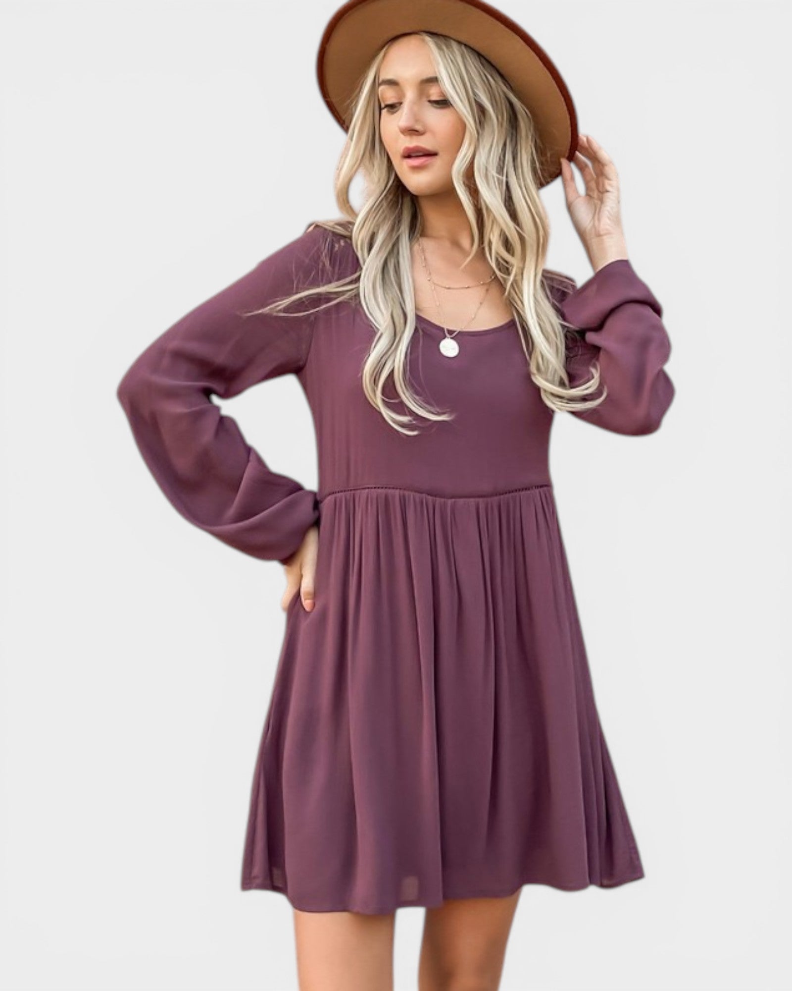 Woman wearing a purple dress and brown hat on a white background