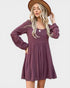 Woman wearing a purple dress and brown hat on a white background