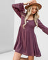 Woman wearing a purple dress and brown hat on a white background