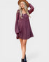 Woman wearing a purple dress with a brown hat on a white background