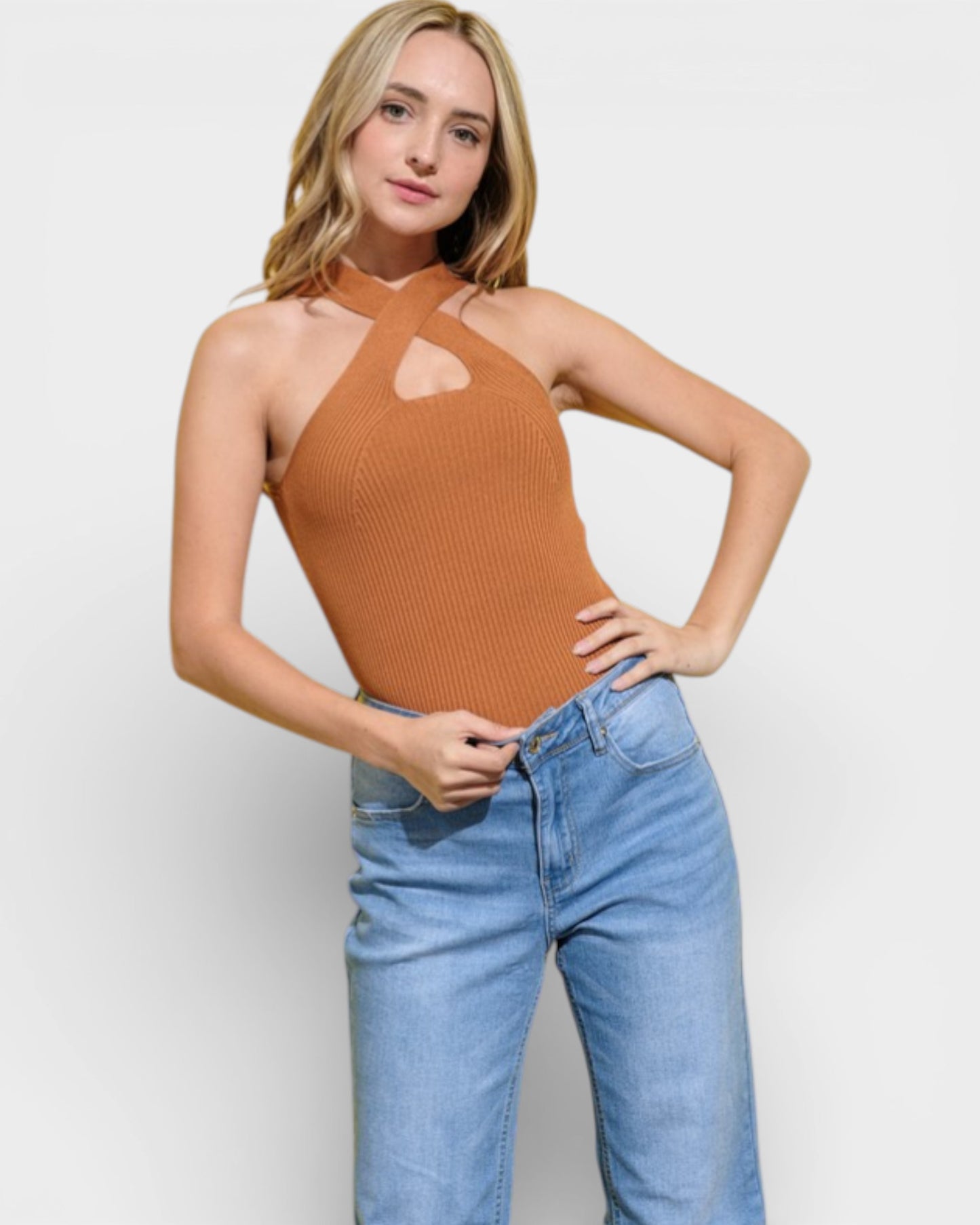 Woman wearing a brown halter top and blue jeans on a white background