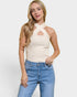 Woman wearing a beige halter top with cut-out design and blue jeans on a white background
