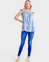 Woman wearing a blue tie-dye top and blue jeans on a white background