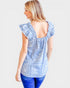 Woman wearing a light blue lace top with ruffled sleeves on a white background