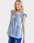 Woman wearing a blue floral top with ruffled sleeves on a white background