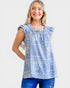 Woman wearing a blue floral top with ruffled sleeves on a white background