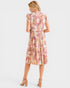 Woman wearing a patterned dress on a white background