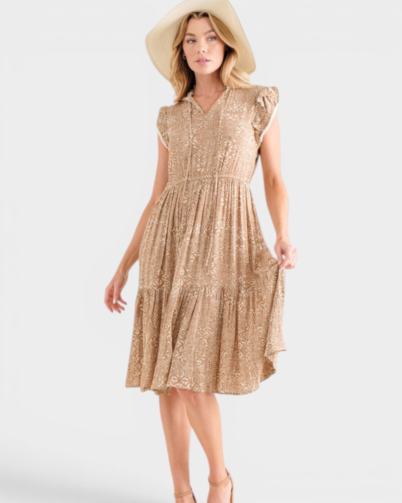 Woman wearing a gold sequin dress and beige hat on a white background