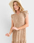 Woman wearing a beige dress and hat on a white background