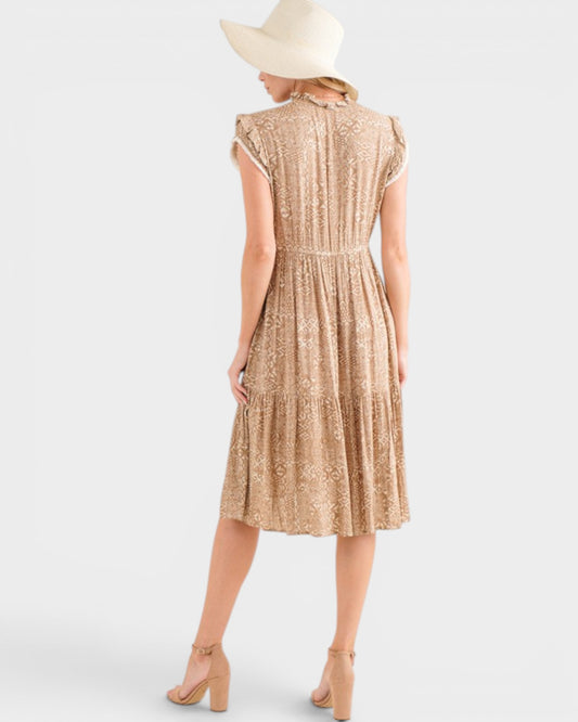 Woman wearing a beige patterned dress on a white background