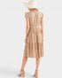 Woman wearing a beige patterned dress on a white background