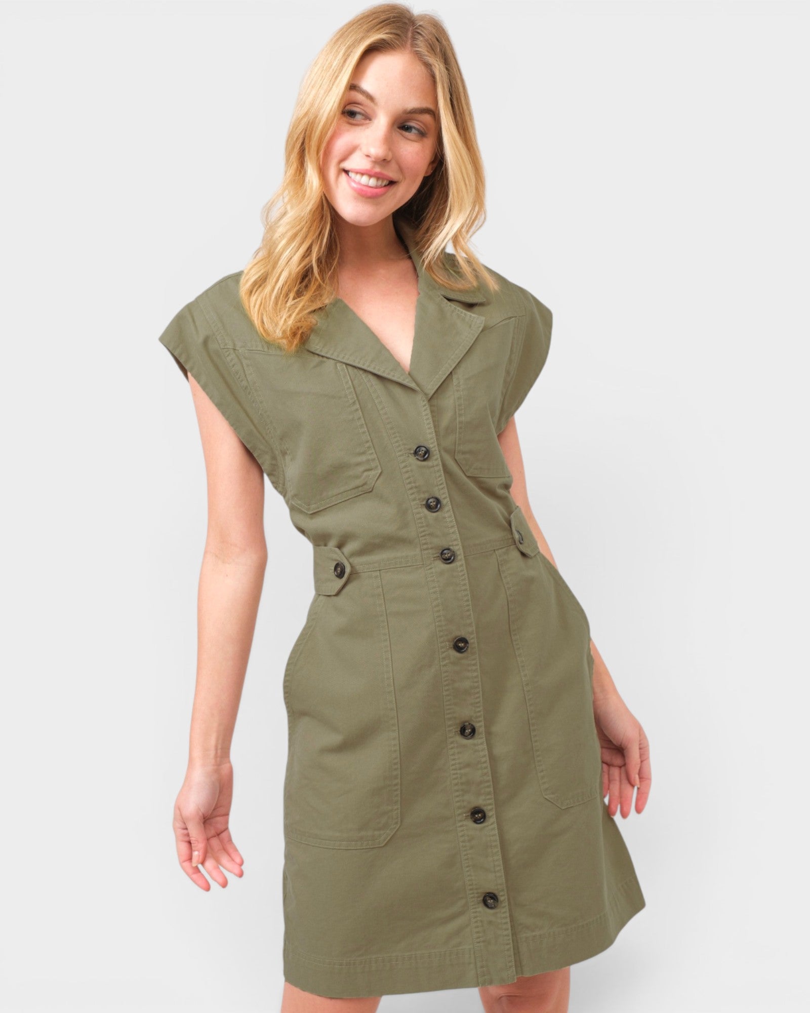 Woman wearing a green dress with buttons on a white background