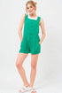 Woman wearing a green romper with a white background