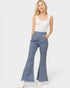Woman wearing blue checkered flared pants and a white top on a white background