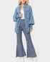 Woman wearing a denim jacket and checkered pants on a white background